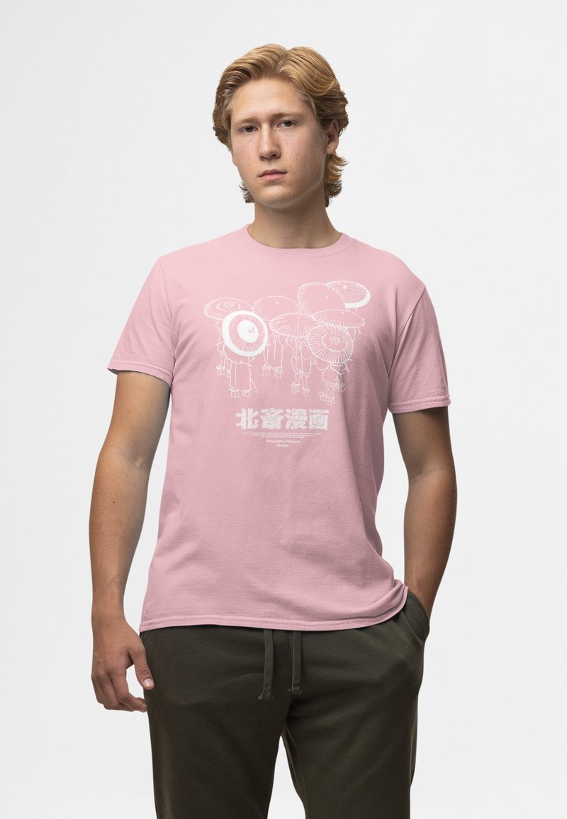 Camiseta de algodón de color rosa claro con un estampado gráfico blanco de personajes con sombreros. Mangas cortas, cuello redondo. Corte casual.