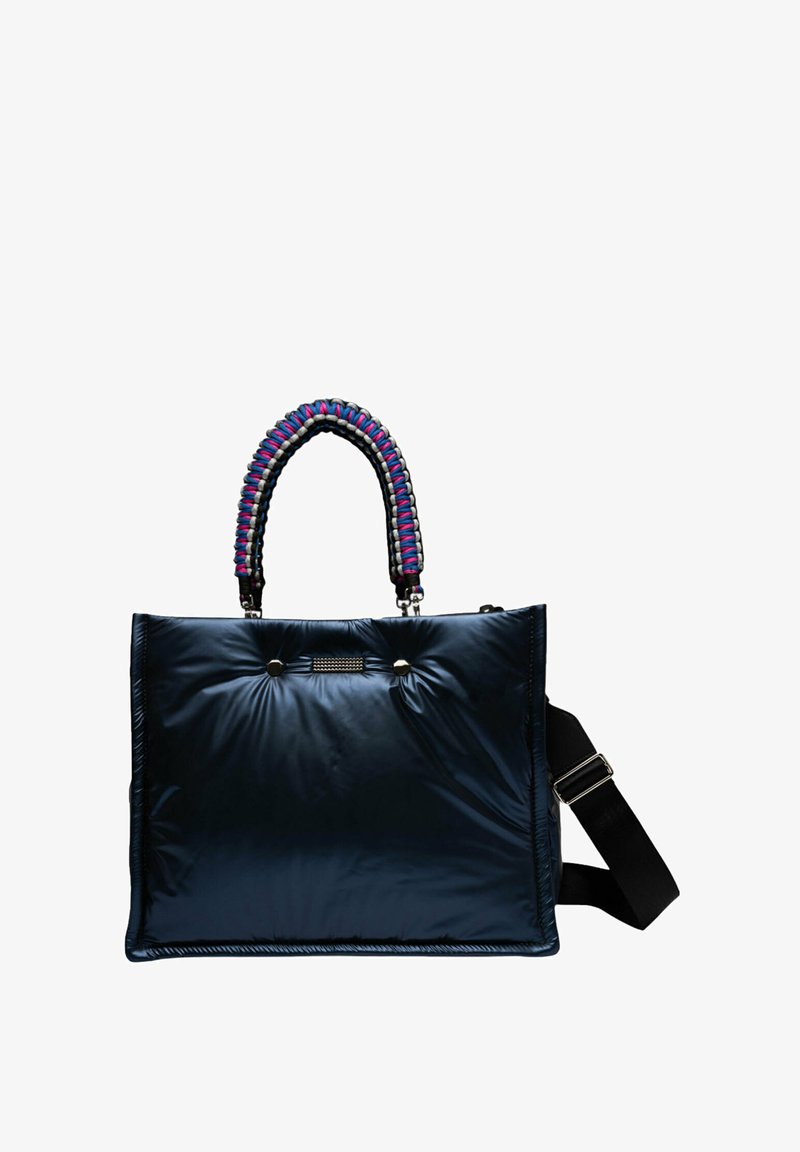 Sac de toile matelassé bleu marine avec une poignée tressée, orné d'accents violets, bleus et gris ; une bandoulière noire réglable est incluse.