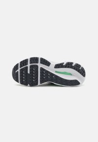 Sportieve schoenzool met een zwart rubberen patroon, witte tussenzool en groene accenten. Ontworpen voor grip en comfort.