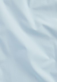 Hellblauer Stoff mit glatter Textur, der subtile Falten und Knicke aufweist und einen sanften, gleichmäßigen Farbton durchgängig zeigt.