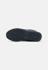 Suela de zapato para hombre Geox, hecha de goma, con un agarre texturizado y surcos con patrón de color oscuro. Contiene la marca en el talón.