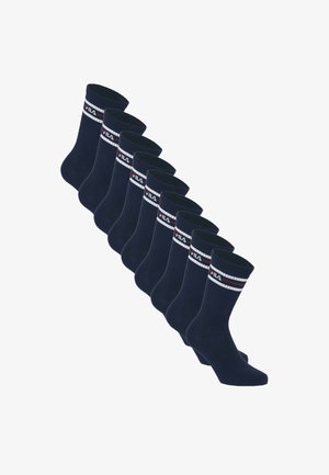 Huit paires de chaussettes mi-mollet noires avec des rayures blanches et rouges et le logo FILA près du haut, disposées en diagonale sur un fond blanc.