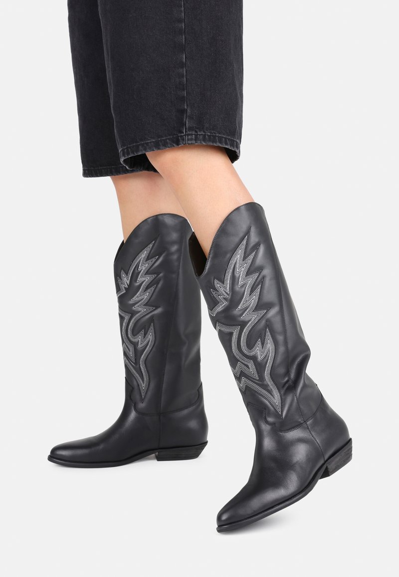 Fekete bőr cowboy csizma díszítő ezüst varrással, villám mintázattal, hegyes orral és alacsony sarkával.