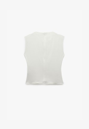 Hvid ærmeløs top med rund halsudskæring, struktureret stof og en central bagsøm, udstyret med en diskret lynlåslukning.