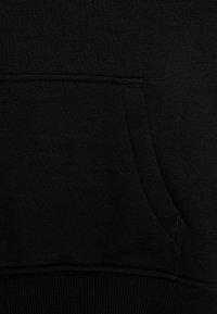 Sweatshirt preto com bolso canguru, punhos e bainha canelados, e tecido liso e texturizado. O design é simples, sem padrões visíveis.
