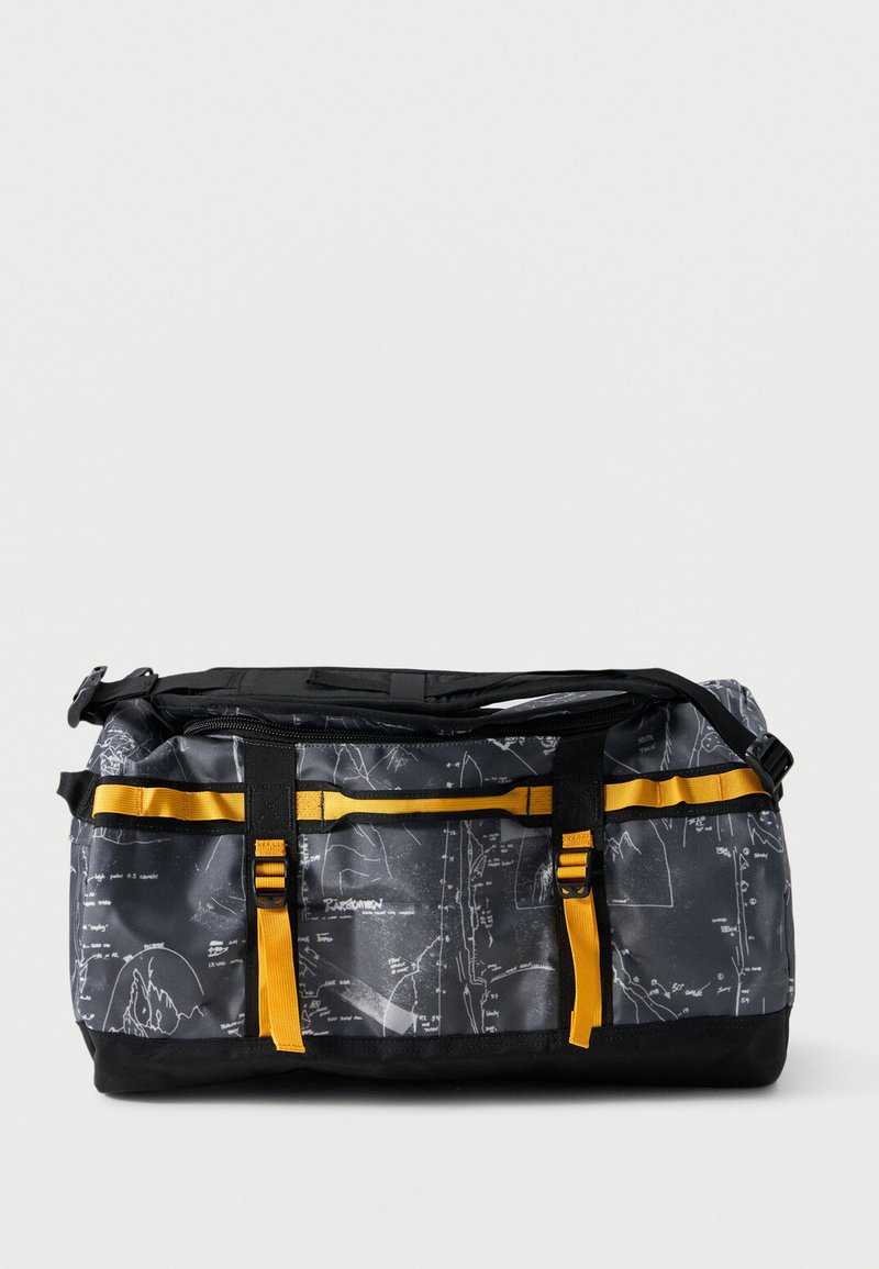 Μαύρη και γκρίζα τσάντα duffel με λευκά μοτίβα χάρτη, κίτρινους ιμάντες, μαύρα κλιπ και ρυθμιζόμενο ιμάντα ώμου σε απλό φόντο.