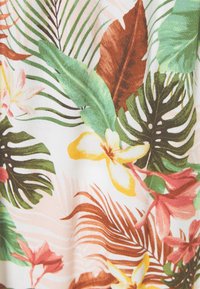 Motivo di stoffa floreale tropicale con foglie di palma verdi, fronde marrone ruggine e fiori di ibisco rosa e gialli su sfondo bianco.