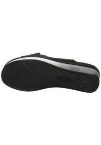 Scarpa nera con una superficie superiore testurizzata e una soletta in gomma sagomata caratterizzata da piccole puntini in rilievo per la presa e un design curvo nel tallone.