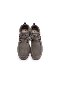 Scarpe in suede marrone con un design arrotondato, dotate di lacci e suola in gomma. Comprendono un accento marrone e rosso sul tallone.