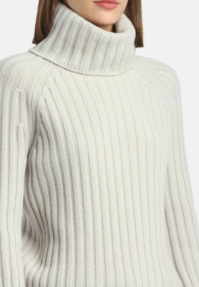 Maglione a collo alto color crema con texture a coste verticali, maniche lunghe e materiale in maglia morbida.