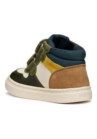 Sneaker alta che presenta materiali misti: pelle verde e crema, suede marrone, con un colletto in tessuto blu e lacci decorativi.