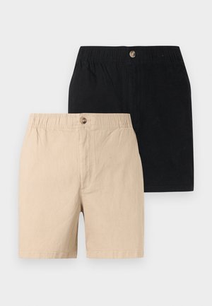 Twee paar katoenen korte broeken, één beige en één zwart, elk met een elastische tailleband en een enkele knoopsluiting.