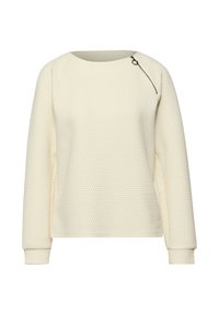 Pull matelassé crème à manches longues avec col rond et une fermeture éclair diagonale près de l'épaule gauche.