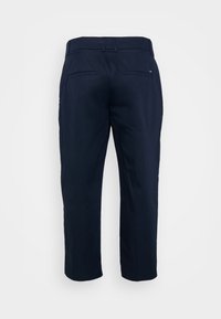 Marineblauwe broek met een rechte snit, gemaakt van een soepele stof. Heeft twee achterzakken en een tailleband zonder zichtbare bevestigingsmiddelen of versieringen.