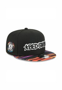 Black snapback cap with white "BED STUFF" logo on front, featuring a vibrant patterned brim in orange, pink, and blue. Side patch displays "Brooklyn."