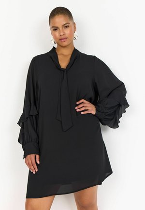 Rochie neagră cu guler legat, mâneci lungi cu volane și o siluetă ușor evazată. Fabricată dintr-un material ușor, cu o textură netedă.