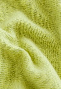 Weicher, leichter Strickstoff in leuchtendem Hellgrün, mit glatter Textur und feinem, gleichmäßigem Stichmuster mit leichten Variationen.