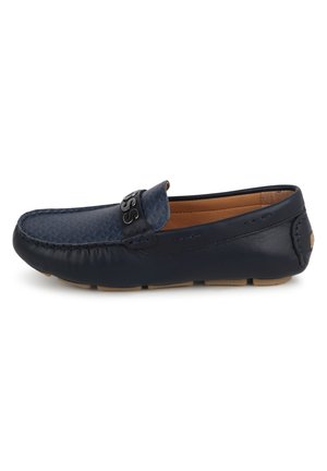 Mocassini in pelle blu navy con un design testurizzato, cuciture visibili e un accento nero con il marchio sulla fascetta. Suola in gomma per una buona aderenza.
