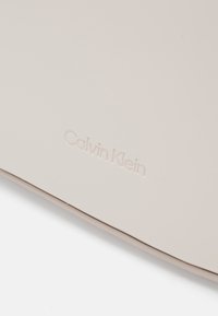Calvin Klein REFINED SCULPT BAG SHINY - Bolso de mano - gray morn
