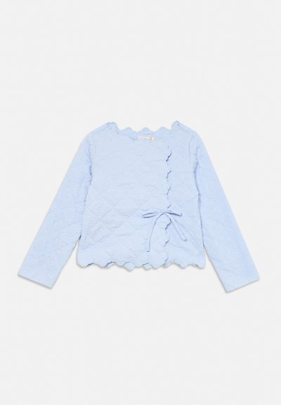 Bluză tip wrap cu mâneci lungi, albastru deschis, cu margini ondulate și model floral texturat, legată cu o fundă laterală în talie.