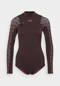 Costum umed maro cu mâneci lungi din plasă cu model. Prezintă un guler înalt, un logo subtil pe piept și accente roz la deschiderea picioarelor.