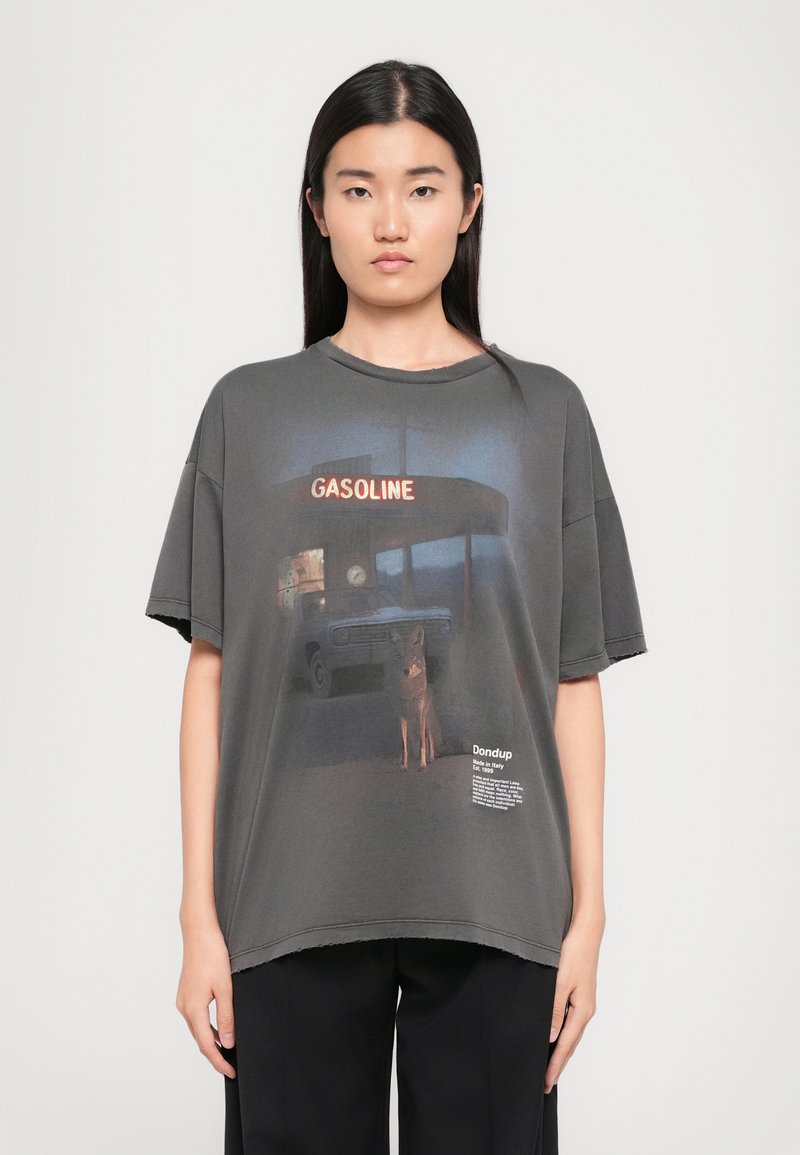 Tricou oversized gri cu un print grafic al unei stații de alimentare cu un câine, margini uzate și detalii tipărite cu logo în zona tivului.