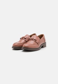 Bruna läderloafers med rund tå och dekorativ spänne, med en låg klack och sydda detaljer runt kanten.