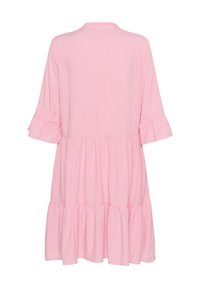 Rosa knälång klänning tillverkad av mjukt tyg med volangkrage och ärmar, med en flerlagerskjoldesign.