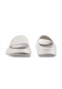 Light gray slip-on sandals feature an open design with wide cutouts, smooth texture, and a contoured footbed for comfort.