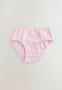 Roze katoenen slip met een gladde textuur, voorzien van een witte strikaccent en gekartelde afwerking langs de beenopeningen. Klassiek slipontwerp.