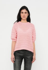 Ροζ πλεκτό πουλόβερ με κοντά μανίκια, με υφασμένο σχέδιο και ριμπ τελείωμα. Συνδυάζεται με μαύρο υφασμένο παντ ελόνι.