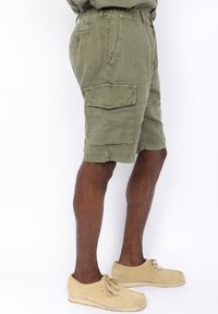 Olijfgroene cargoshorts met een elastische tailleband, zijzakken en een gestructureerde stof. Bevat een cargozak op het been.