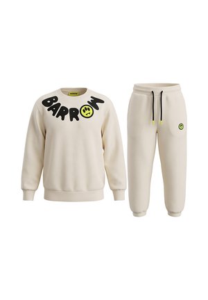 Sudadera color crema y pantalones de chándal a juego, con cordones negros y letras negras llamativas, sobre un fondo blanco.