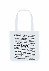 Borsa a spalla bianca in tela con diverse traduzioni della parola "amore" in tipografia nera, e la parola "AMORE" in evidenza in un font più grande.