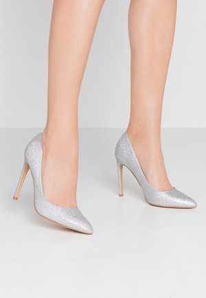 Silver glitter high heels with a pointed toe and a slim stiletto heel. Smooth texture and minimalist design, suitable for formal occasions.