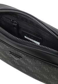 Borsa clutch nera con texture, dotata di chiusura con zip, tasca interna e etichetta con marchio su una fodera in tessuto decorato.