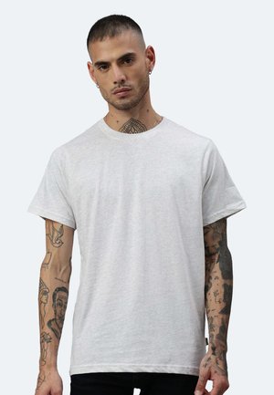 T-shirt grigio chiaro a maniche corte in cotone con scollatura a girocollo e vestibilità comoda. Presenta tatuaggi visibili sulle braccia.