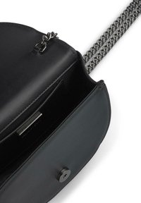 Czarna skórzana torebka na ramię z srebrnym łańcuszkiem, o zaokrąglonym kształcie, z kieszonką wewnętrzną i zatrzaskiem magnetycznym.