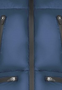 Granatowa kurtka puchowa o pikowanym wzorze, z dwoma zasuwanymi kieszeniami i kontrastującymi czarnymi suwakami wzdłuż przedniej części.