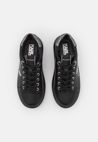 Baskets en cuir noir avec des accents métalliques, bout rond, design à lacets, et un dessus texturé avec un logo sur la languette.