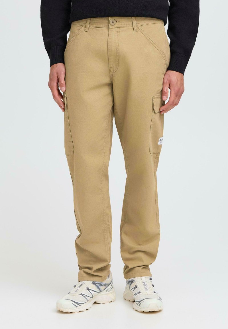 Les pantalons cargo beige présentent une coupe décontractée, une taille plate et des poches latérales. Fabriqués en coton, ils ont une texture lisse et un design durable.