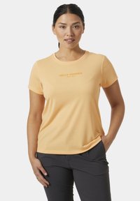 Světle oranžové tričko s krátkým rukávem vyrobené z měkké tkaniny, s kulatým výstřihem a logem "Helly Hansen" v kontrastní barvě na přední straně.