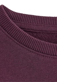 Lila Sweatshirtstoff mit einem gerippten Rundhalsausschnitt und feiner Textur, der Nähdetails und ein weiches Innenfutter zeigt.