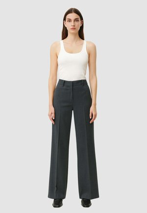 Pantaloni grigi a vita alta e gamba larga realizzati in tessuto testurizzato. Abbinati a un top aderente bianco, design minimalista, senza motivi notevoli.