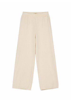 Beżowe spodnie z szerokimi nogawkami, wysokim stanem i małą złotą metką marki u góry na białym tle.