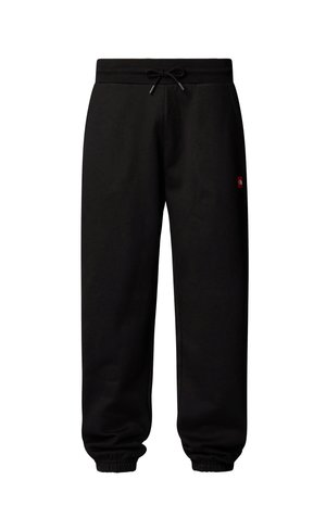 Black sweatpants made from cotton with an elastic waistband and drawstring. Cuffs are elasticized. Features a small red logo patch.