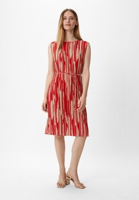 Rot- und cremefarbener gestreifter Kleid mit betontem Taillenbereich, ärmellosem Design, knielangem Saum und glatter Stoffstruktur.