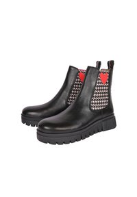 Stivaletti in pelle nera con suola spessa, caratterizzati da un motivo houndstooth e dettagli a forma di cuore rossi sui pannelli laterali.