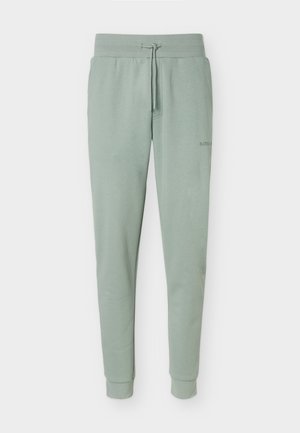 Lysegrønne sweatpants med elastisk talje, snøre, sidelommer og ribbede manchetter, vist mod en hvid baggrund.