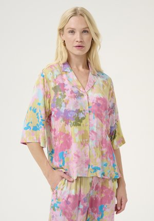 Colorful patterned pajama set featuring a short-sleeve shirt with a button placket, in pink, green, and blue hues, made of soft fabric.